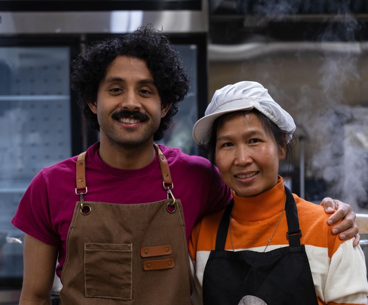 Sujit Acharya and head chef Amone smiling side by side in the MomoNepal kitchen